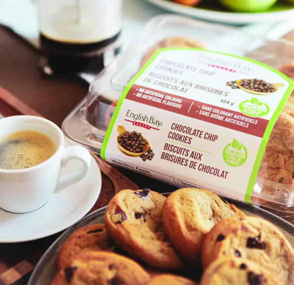 Emballage de biscuits aux brisures de chocolat English Bay Bakery sans colorants artificiels, posé sur une table avec une tasse de café
