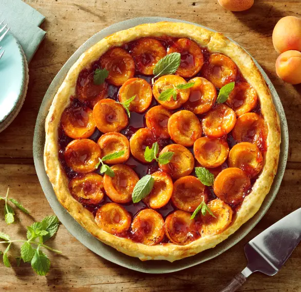 Tarte aux abricots décorée de feuilles de menthe fraîche