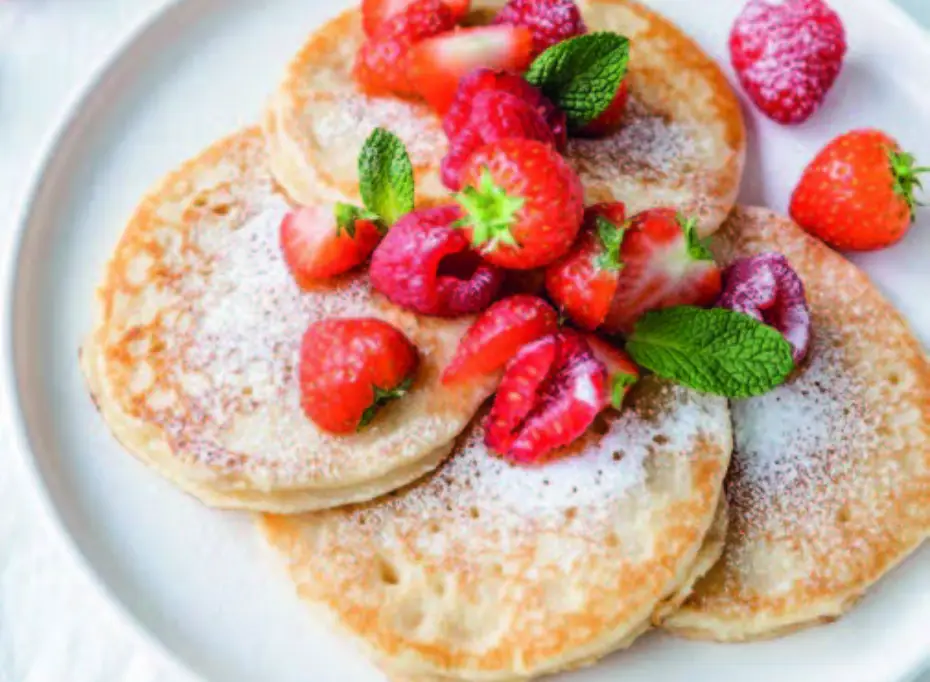 Pancakes garnis de fraises fraîches et de feuilles de menthe