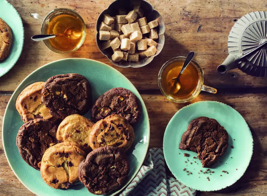 Assiette de cookies au chocolat avec du thé et des morceaux de sucre